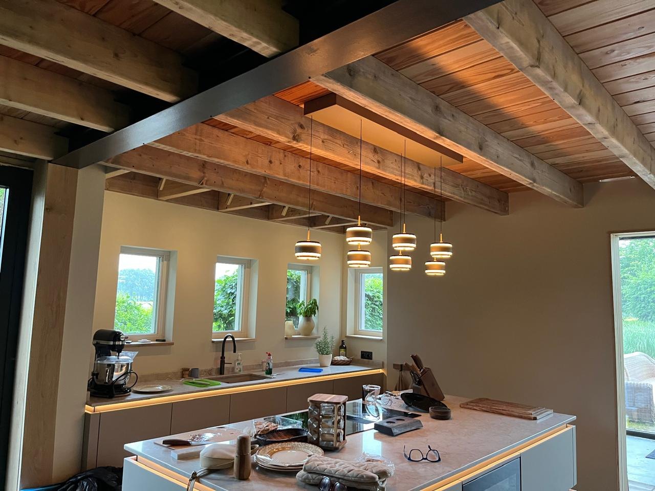 Renovated open-plan kitchen with exposed timber ceiling beams and pendant lighting, part of ALLROUND4YOU's completed work